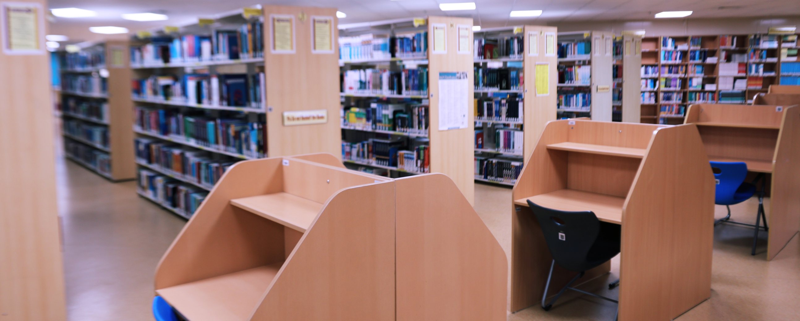 Individual study carrels in the RAK MHSU Library, with the book stacks behind them